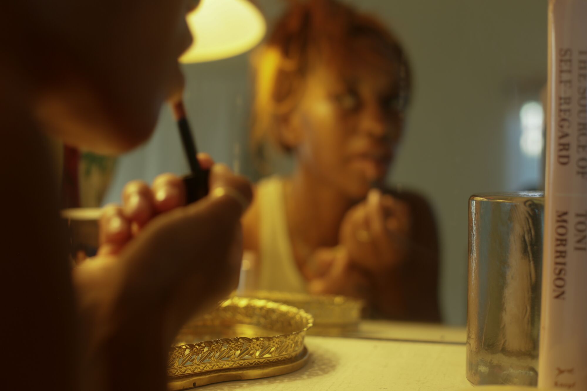 Rikkí Wright applying lipstick in the mirror.