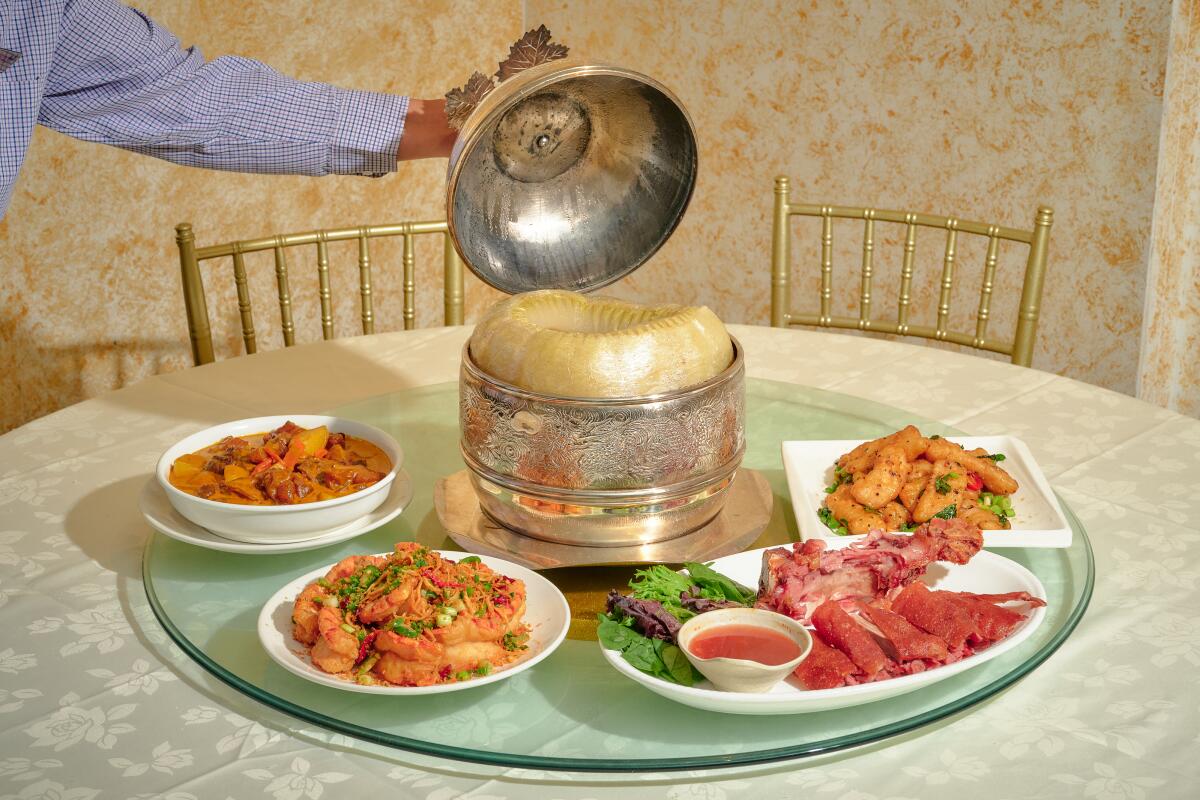 ALHAMBRA , CA - NOVEMBER 2: (From left to right) The beef curry stew, tiger prawns, deep fried salted pigs feet, the Vietnamese style fried fish, and the winter melon soup (center) at Henry's Cuisine on Wednesday, Nov. 2, 2022 in Alhambra , CA. (Shelby Moore / For The Times)