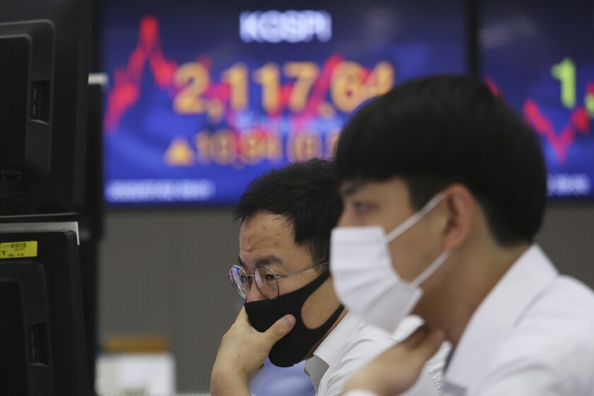 Currency traders watch monitors at the foreign exchange dealing room of the KEB Hana Bank headquarters in Seoul, South Korea, Thursday, July 2, 2020. Asian stock markets followed Wall Street higher Thursday as hopes for development of a coronavirus vaccine competed with concern about rising U.S. infections. (AP Photo/Ahn Young-joon)