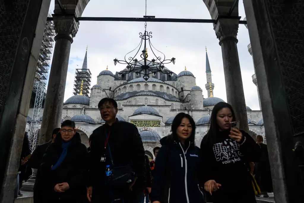 Pope Leo XIV's Lebanon Visit: Significance Amid Israeli Bombardment People in dark clothes standing in the foreground of a grand white mosque with blue domed roofs