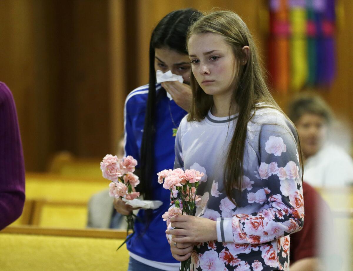 Rachel Marsh, right, and Selena Orozco, both 15, attend a prayer service after the mass shooting that left five dead at a mall in Burlington, Wash.