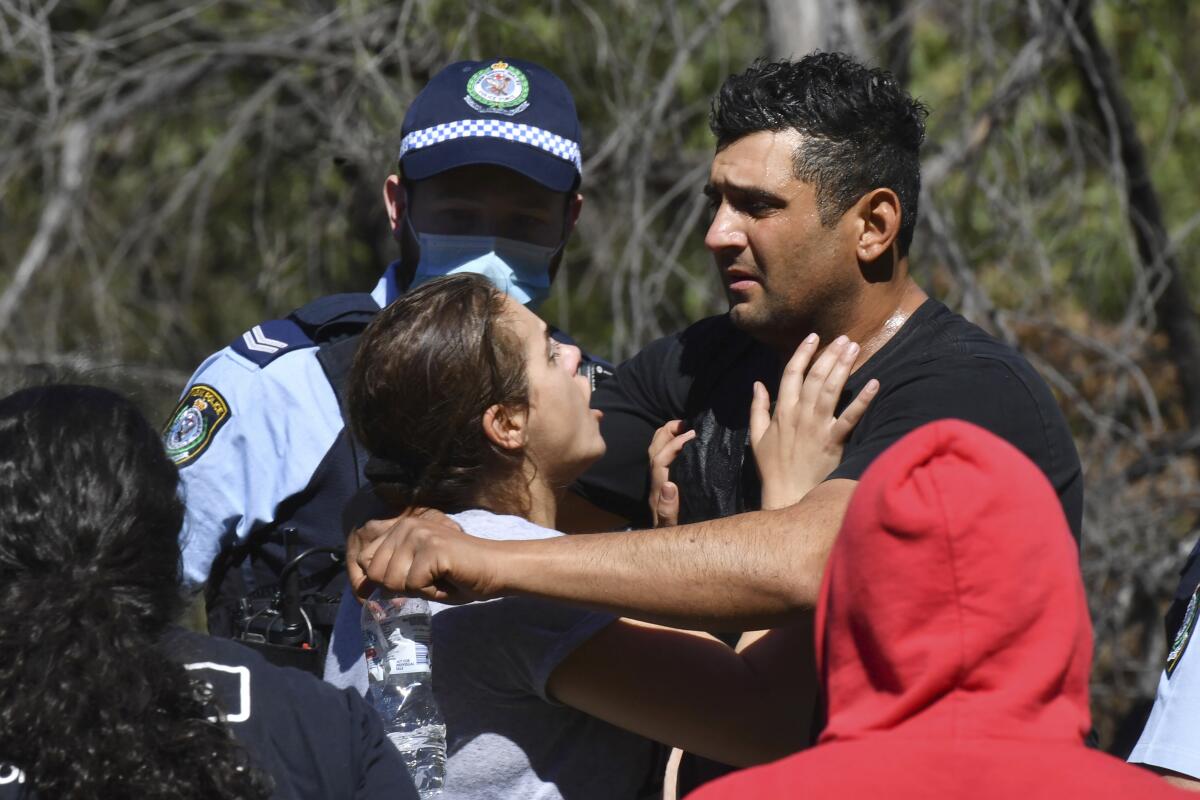 Anthony Elfalak, right, and his wife, Kelly, embrace after hearing their son AJ is found alive on the family property near Putty, north west of Sydney, Australia, Monday, Sept. 6, 2021. Three-year-old AJ was found sitting in a creek and cupping water in his hands to drink three days after he was lost in rugged Australian woodland. (Dean Lewins/AAP Image via AP)
