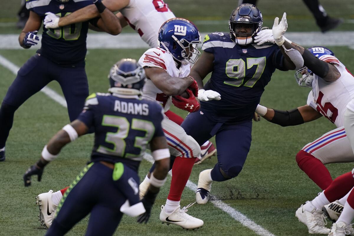 New York Giants running back Alfred Morris carries the ball past Seattle Seahawks defensive tackle Poona Ford.