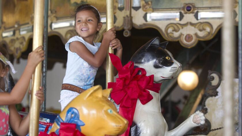 Isabella Ramirez atop of a cat figure on the Balboa Park Carousel. The Friends of Balboa Park group are the new owners of the landmark Carousel next to the zoo. On National Carousel Day last year, the group launched the public portion of their $3 million fundraising campaign.