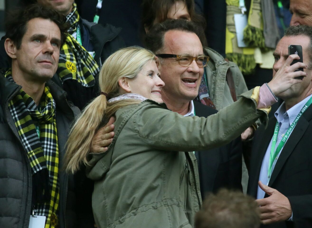 Actor Tom Hanks and a young woman take a selfie as director Tom Tykwer, left, looks on at the DFB Cup final between Borussia Dortmund and FC Bayern Munich at the Olympic Stadium in Berlin on May 17, 2014.
