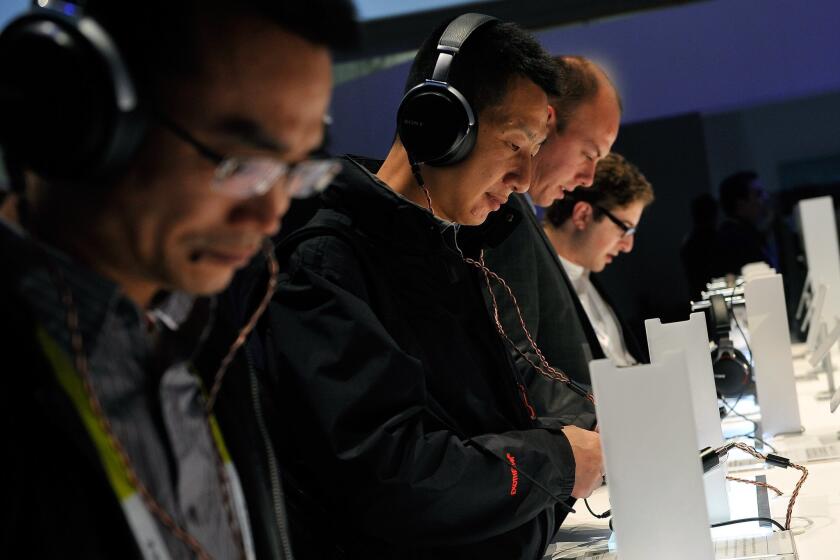 Attendees listen to music with Sony's MDR-1A headphones at the 2015 International CES at the Las Vegas Convention Center on Tuesday in Las Vegas. How online music listening and advertising fit together were among the key discussions at CES for the entertainment industry.