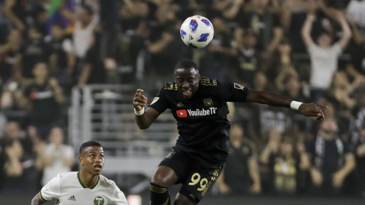 LAFC forward Adama Diomande, right, heads the ball away from Portland's Jeremy Ebobisse on July 18 at Banc of California Stadium.