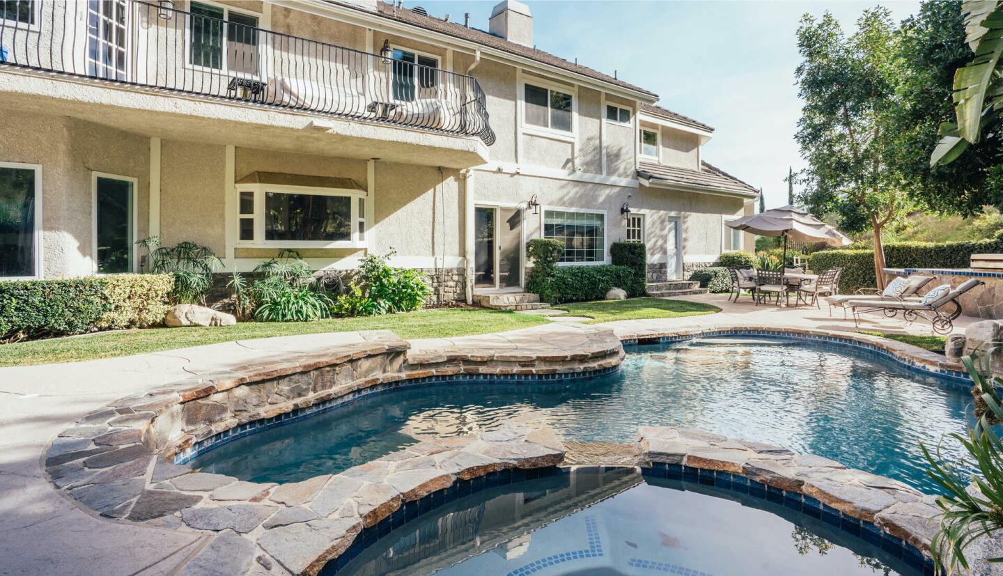 Daytime view of the backyard and pool, with stone surround.