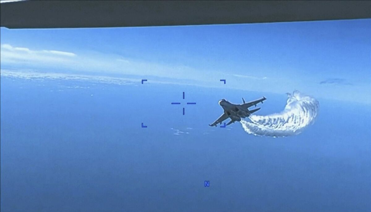 This photo taken from video released on Thursday, March 16, 2023, shows a Russian Su-27 approaching the back of the MQ-9 drone and beginning to release fuel as it passes, over the Black Sea, the Pentagon said. The Pentagon has released footage of what it says is a Russian aircraft conducting an unsafe intercept of a U.S. Air Force surveillance drone in international airspace over the Black Sea. (US Department of Defense via AP)