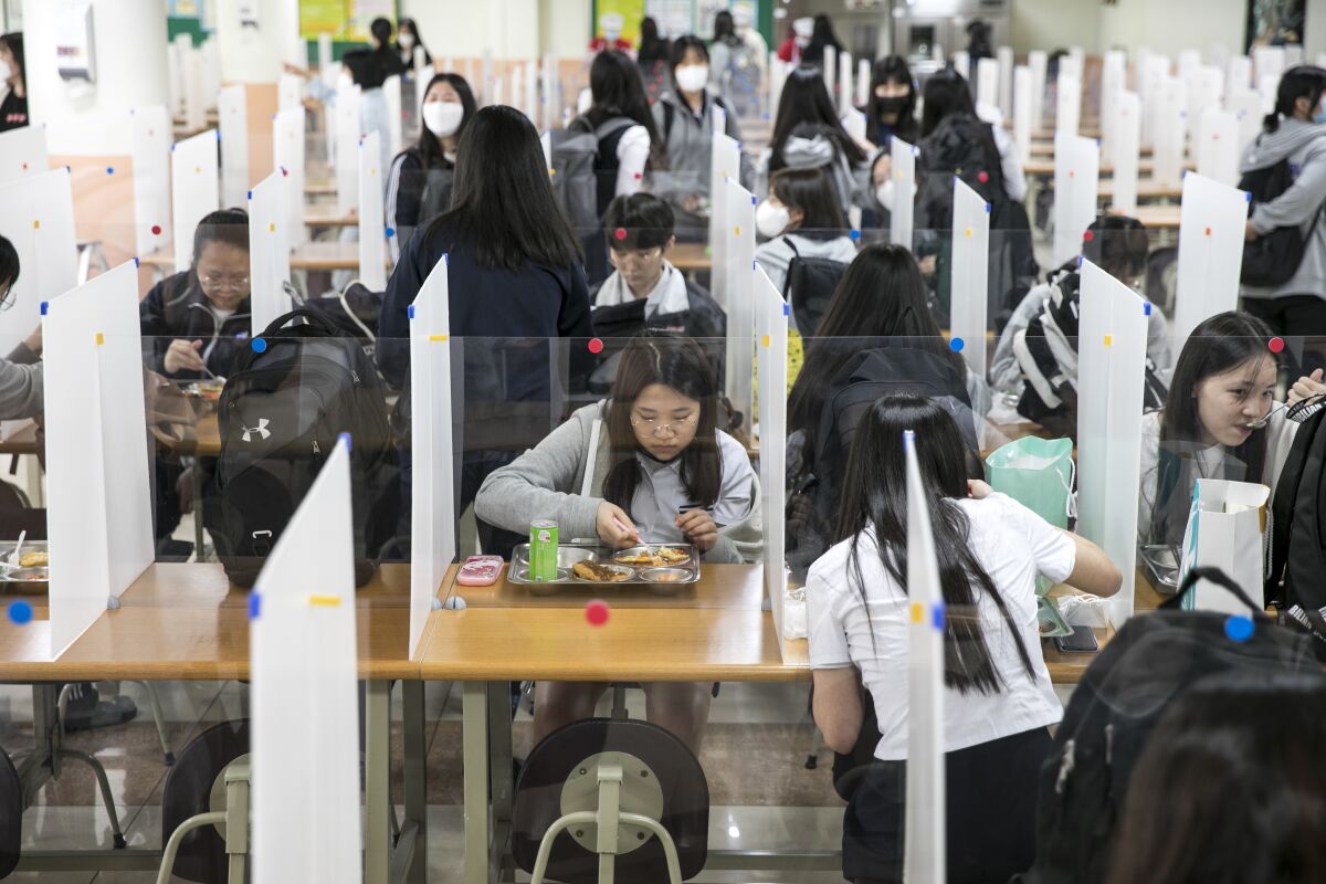 Students at Gyungbuk Girls' High School in South Korea are separated by barriers at lunch time on May 20.