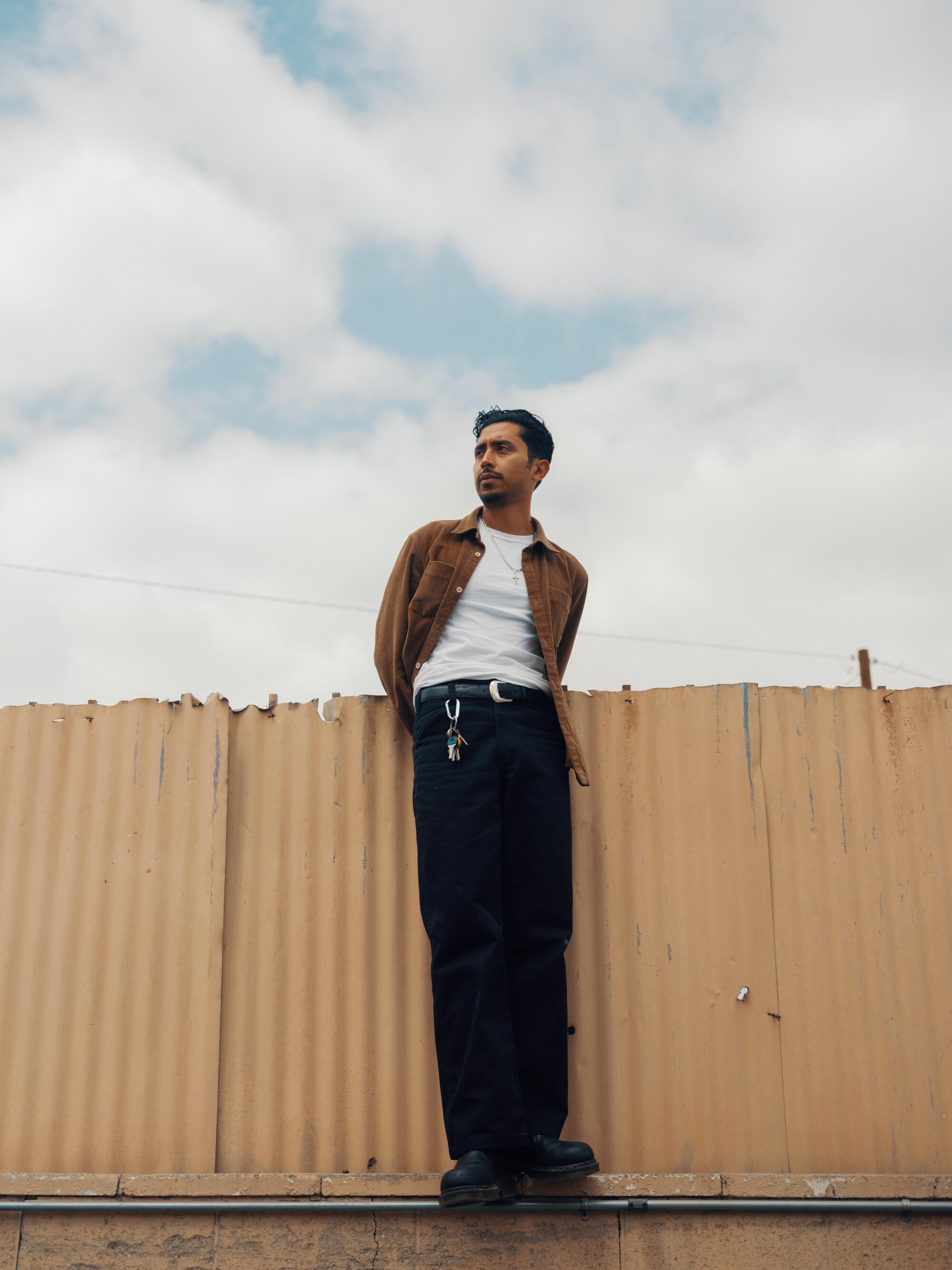 Preciado stands on the fence at Jose Auto Body Shop.