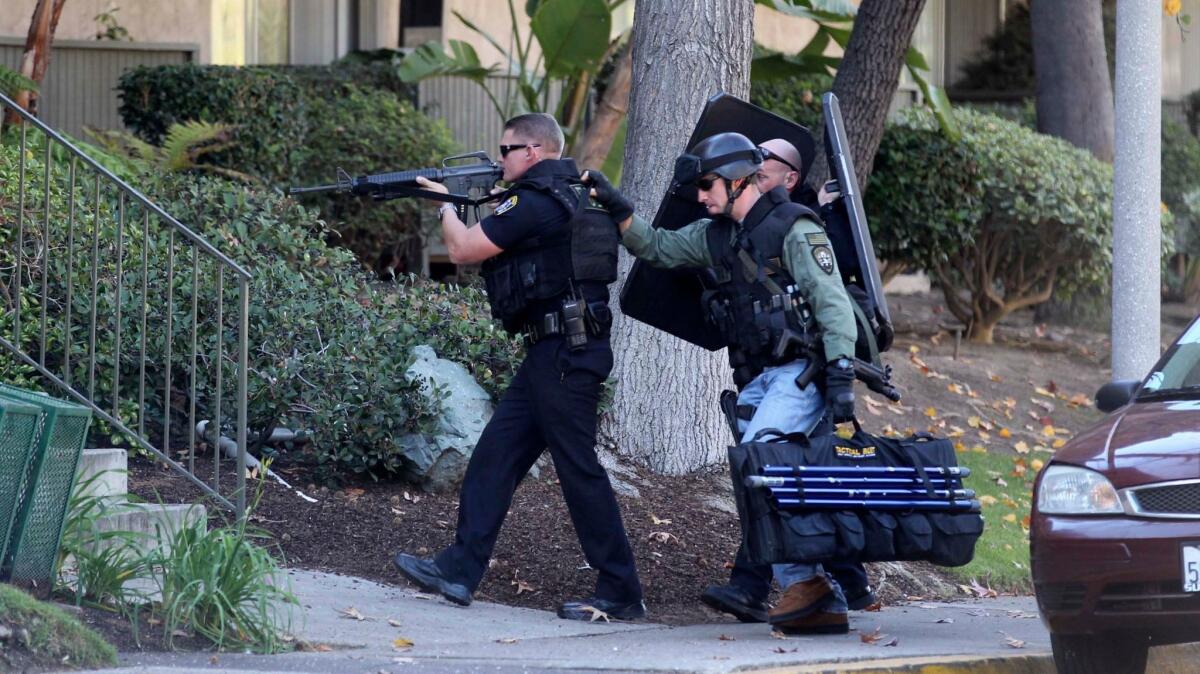 A team of San Diego police officers enter an apartment complex where an officer had shot Angel Lopez, a wanted parolee, on Jan. 17, 2013.