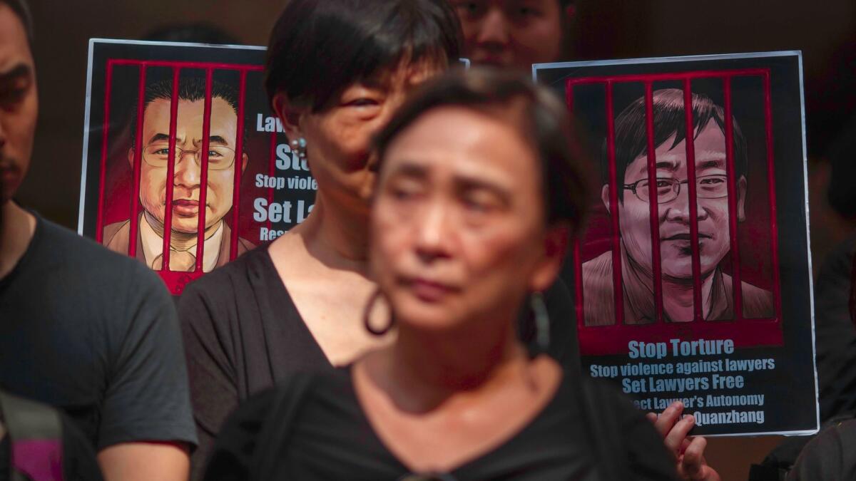 Portraits of detained Chinese human rights lawyers Wang Quanzhang, right, and Jian Tianyong are seen as Hong Kong pro-democracy activists protest in support of human rights lawyers in China on July 9, 2017.