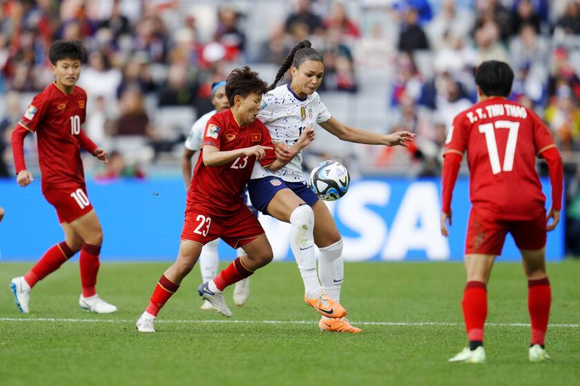 American Sophia Smith fights for the ball while being surrounded by three Vietnam players
