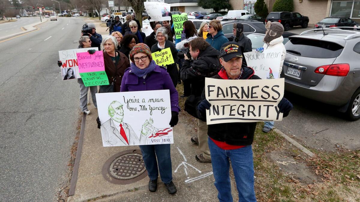 Supporters of Democrat Shelly Simonds in her disputed Virginia House of Delegates race hold a roadside rally in Newport News on Dec. 27.