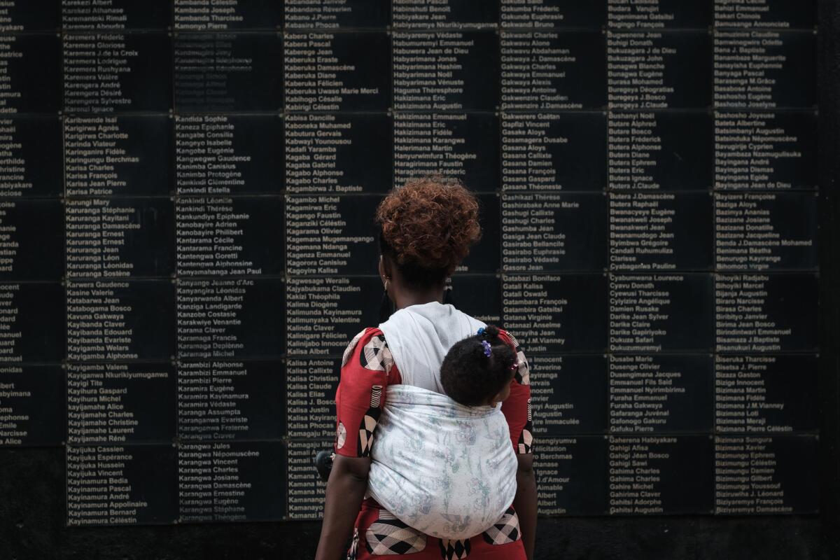 A woman visits the Kigali Genocide Memorial in Rwanda, which features a wall of victims' names.