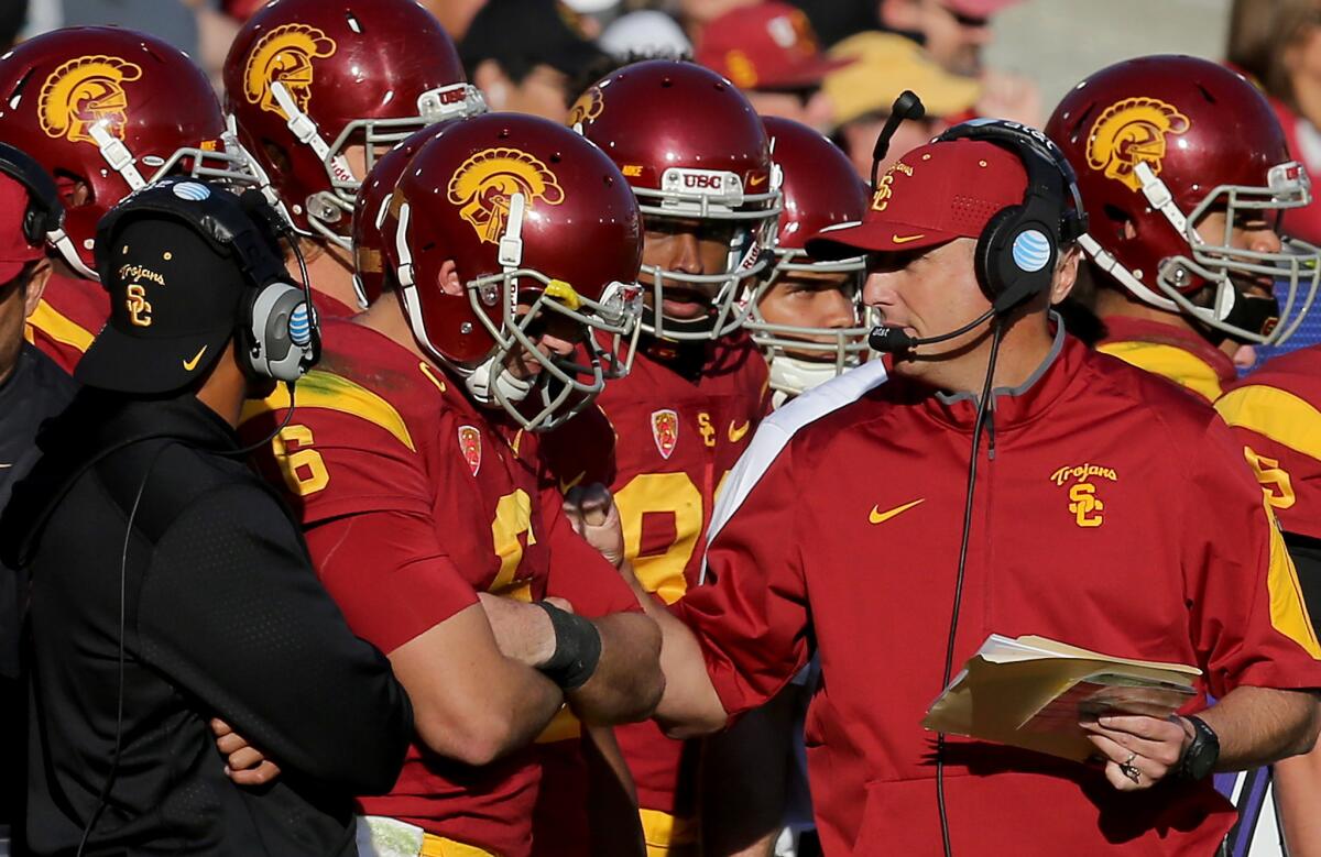 Then USC interim coach Clay Helton talks with quarterback Cody Kessler during the third quarter of a game against UCLA on Nov. 28.