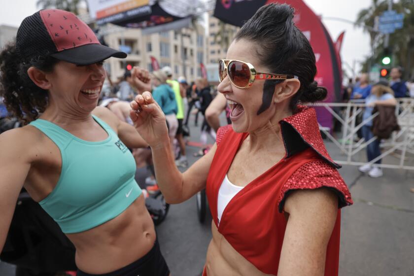 SAN DIEGO, CA - JUNE 04, 2023: Celeste Arumbulo has an Elvis hairdo and sunglasses as she meets other runners at the start line before the start of the Rock 'n' Roll San Diego Marathon on Sixth Avenue in San Diego on Sunday, June 4, 2023. (Hayne Palmour IV / For The San Diego Union-Tribune)