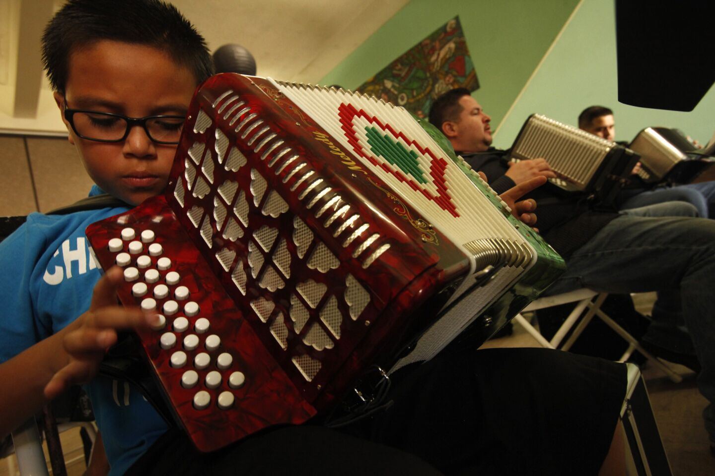 Accordion students Jason Sanchez, left, George Magallanes and Eduardo Rocha learn a new song while Ontono Lujan, not shown, teaches them how to play the button accordion during his weekly Saturday morning class at Plaza de La Raza in Los Angeles. Unlike in American culture, where the accordion is sometimes considered nerdy, in Latino culture it's often quite revered.