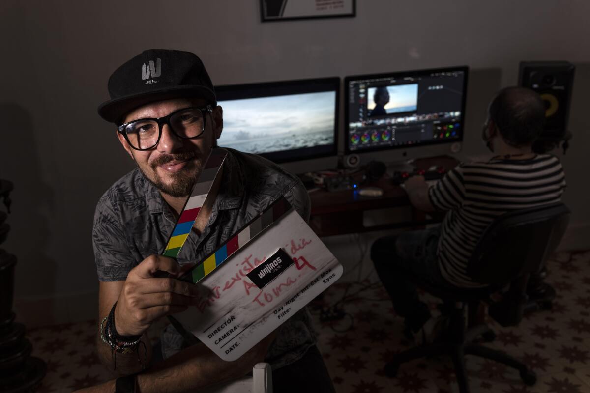 Carlos Gomez, 35, owner of the audiovisual production company Wajiros Films, poses for a photo at his company's editing room in Havana, Cuba, Thursday, Sept. 2, 2021. Most sorts of private businesses have been banned for more than 50 years, but now a new legal system takes effect on Sept. 20 that could greatly expand the scope of private businesses like Gomez´s, and crucially give them greater legal certainty in efforts to help an economy in crisis. (AP Photo/Ramon Espinosa)