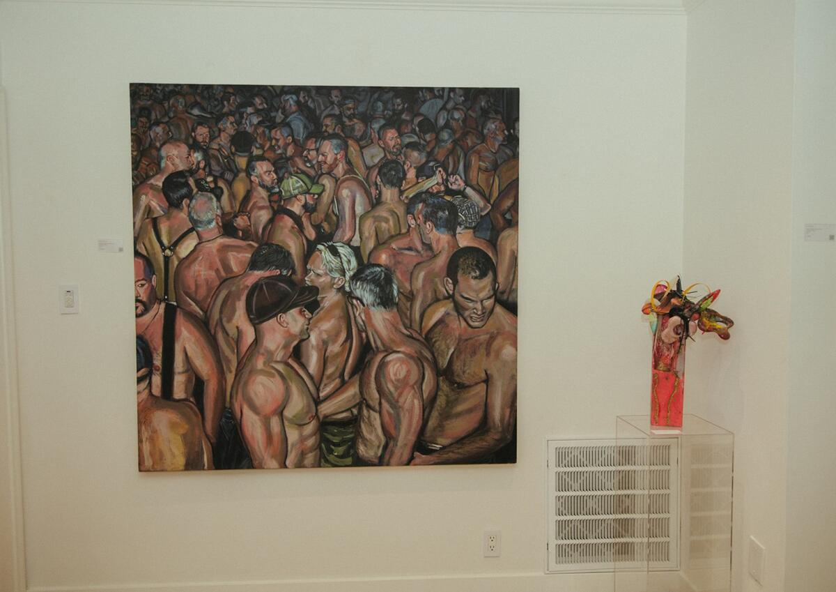 A painting of shirtless men and an ensemblage art piece.