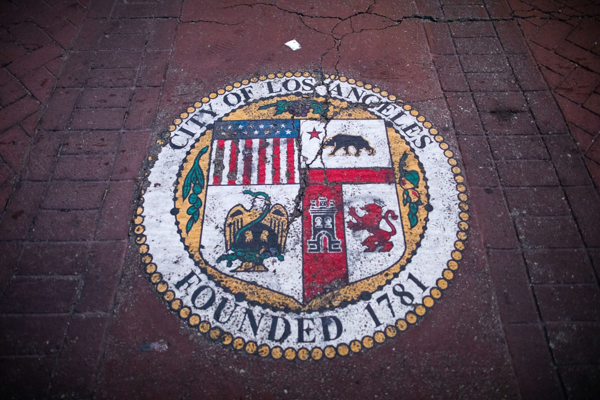 A weathered city seal on a pedestrian crosswalk in front of City Hall in downtown Los Angeles.