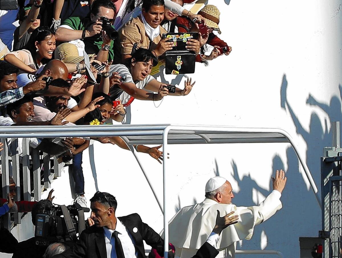 Pope Francis greets the crowd as he leaves a stadium Mass in Amman, Jordan, on the first day of a three-day visit to the Middle East.
