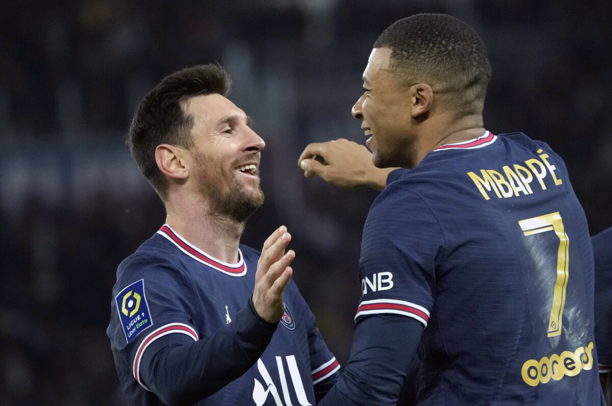 PSG's Kylian Mbappe, centre, celebrates with PSG's Lionel Messi after scoring his side's second goal during the French League One soccer match between Paris Saint-Germain and Monaco at the Parc des Princes stadium in Paris, France, Sunday, Dec. 12, 2021. (AP Photo/Christophe Ena)