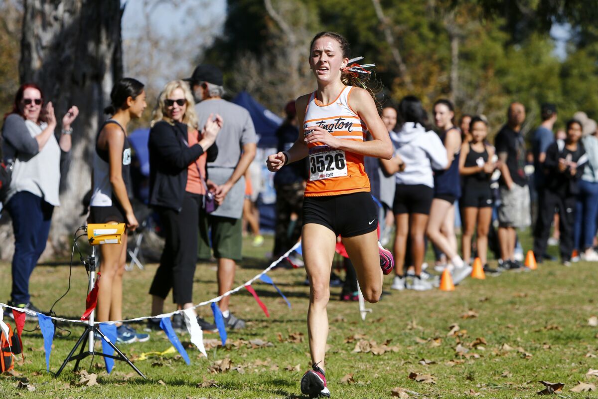 Huntington Beach's Makenzie McRae is first to cross the finish line in the Sunset Conference cross-country finals.