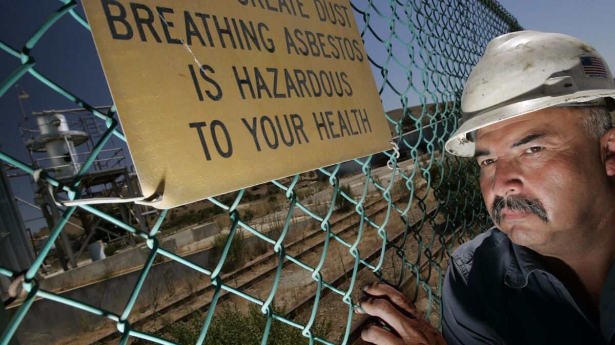Manuel Zuniga stands outside the fence of the KCAC asbestos processing plant off Highway 101 south of King City, Calif.