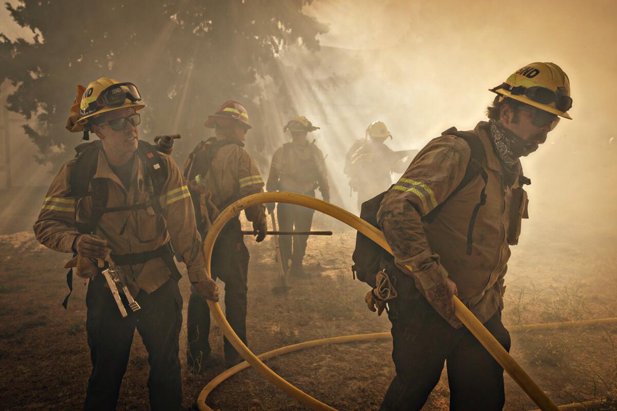 Firefighters work on a hot spot in the Post fire near Gorman on Sunday.