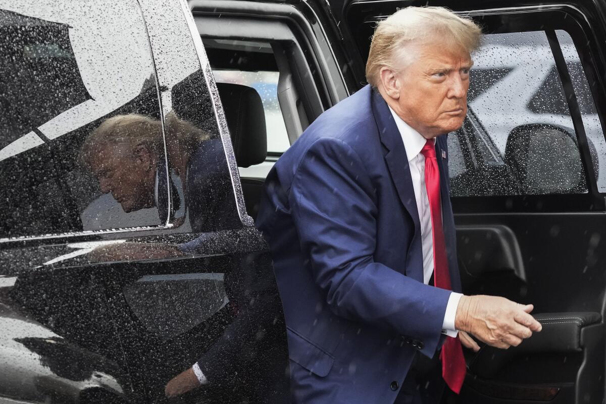 Former President Trump exits a vehicle.