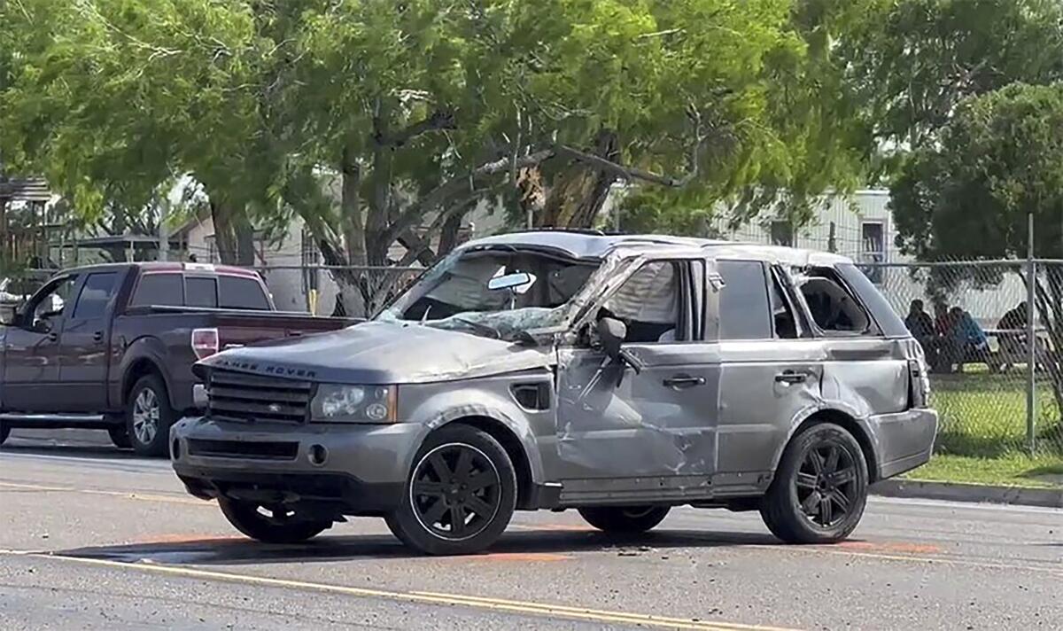 A damaged Range Rover sits at the site of a deadly collision near a bus stop.