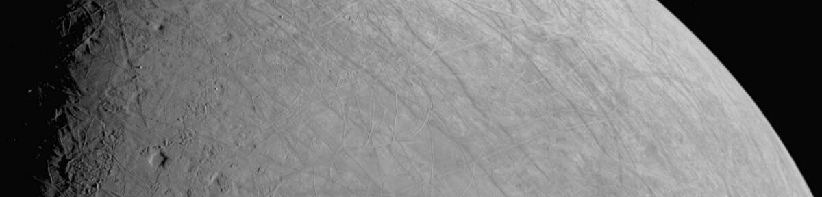 A closeup of Europa's equatorial region, crisscrossed by ridges, troughs and possibly an impact crater.