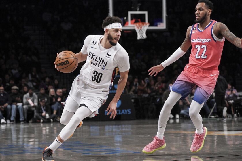 Brooklyn Nets guard Seth Curry, left, drives to the basket against Washington Wizards guard Monte Morris during the first half of an NBA basketball game, Saturday, Feb. 4, 2023, in New York. (AP Photo/Bebeto Matthews)