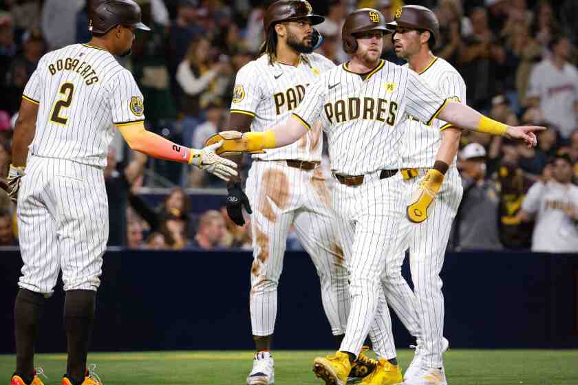 San Diego, CA - April 30: San Diego Padres first baseman Jake Cronenworth (9), right fielder Fernando Tatis Jr. (23), and third baseman Tyler Wade (14) celebrate with second baseman Xander Bogaerts (2) after after scoring on a three run RBI double by designated hitter Manny Machado (13) against the Cincinnati Reds during the fifth inning at Petco Park on Tuesday, April 30, 2024 in San Diego, CA. (Meg McLaughlin / The San Diego Union-Tribune)