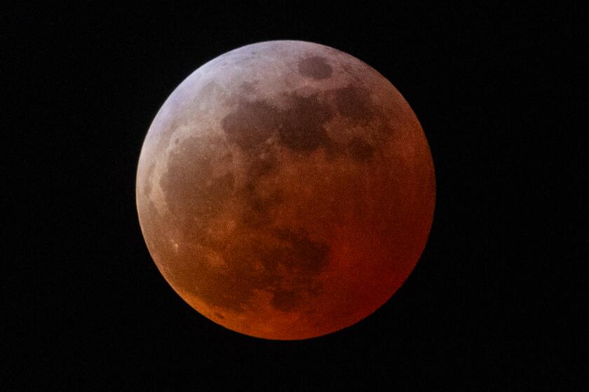 Huntington Beach, CA - March 13: A view of the Blood Moon lunar eclipse as seen from Huntington Beach Thursday, March 13, 2025. A total lunar eclipse is when the Moon falls within the darkest part of Earth's shadow called the umbra. This occurs when the Sun, Earth, and Moon align so that the Moon passes into Earth's shadow.(Allen J. Schaben / Los Angeles Times)