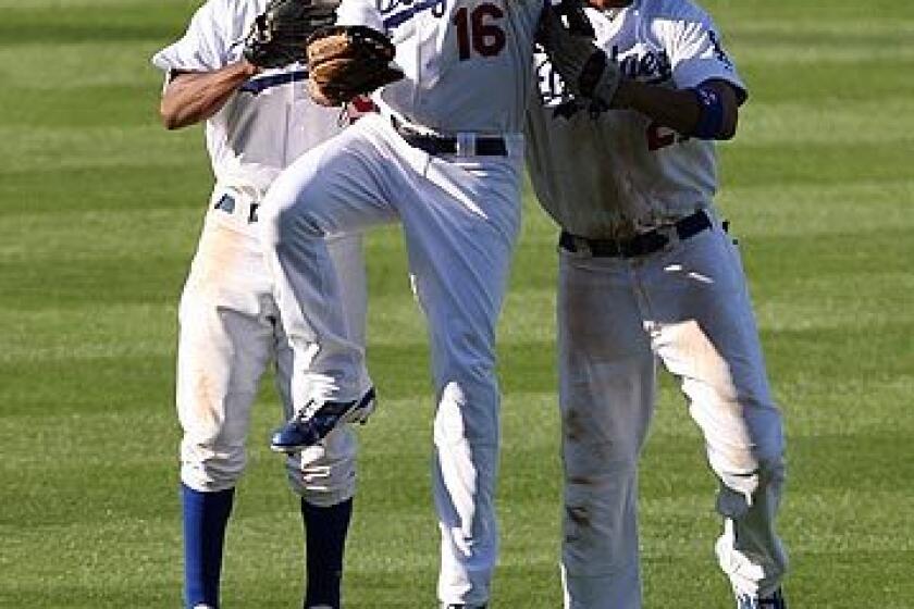 Dodgers outfielders Juan Pierre (left), Andre Ethier (16) and Matt Kemp body bump after beating the Philadelphia Phillies, 2-1, on Friday at Dodger Stadium to even the National League Championship Series at 1-1.