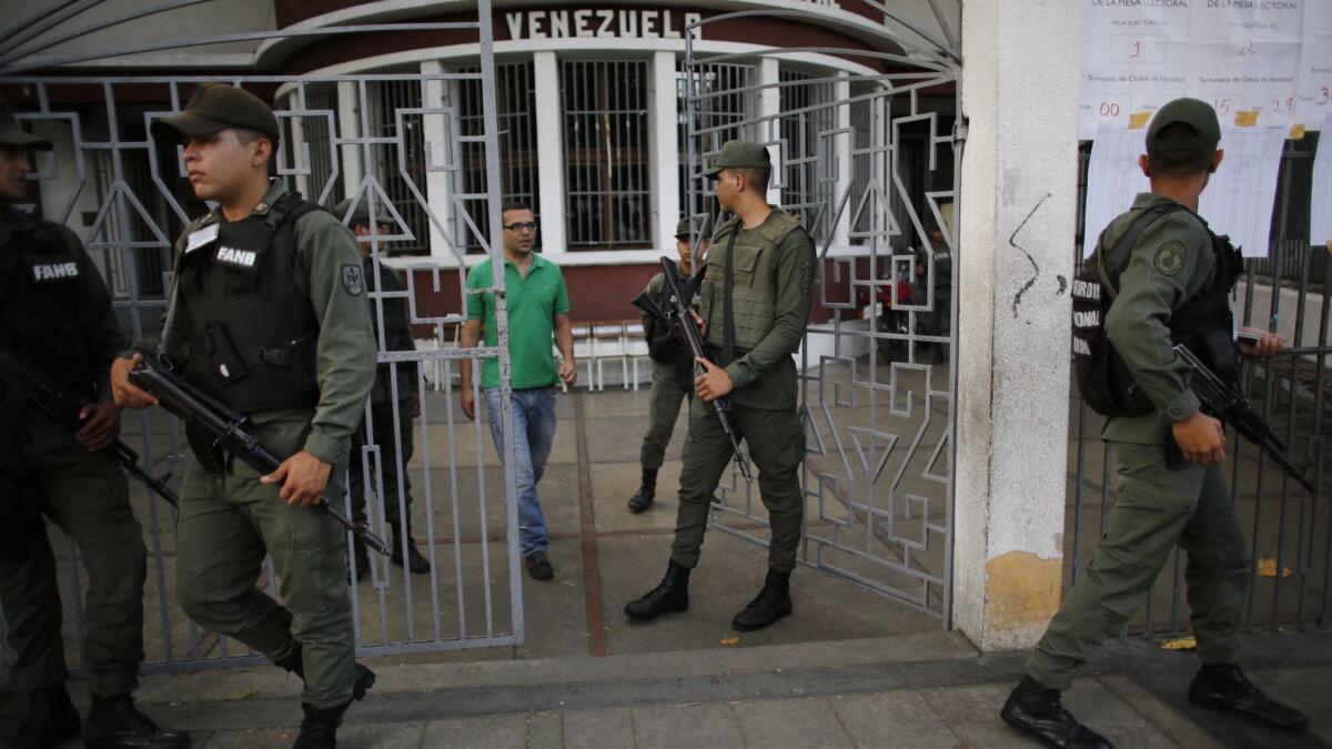 Troops stand guard at a polling station during the presidential election in Caracas, Venezuela, on Sunday.