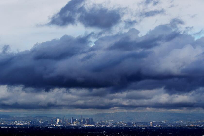 LONG BEACH, CALIF. - DEC. 12, 2022. A December storm drifts over the Los Angeles Basin, producing inclement weather, including rain in urban areas and snow on local mountains on Monday, Dec. 12, 2022.. (Luis Sinco / Los Angeles Times)