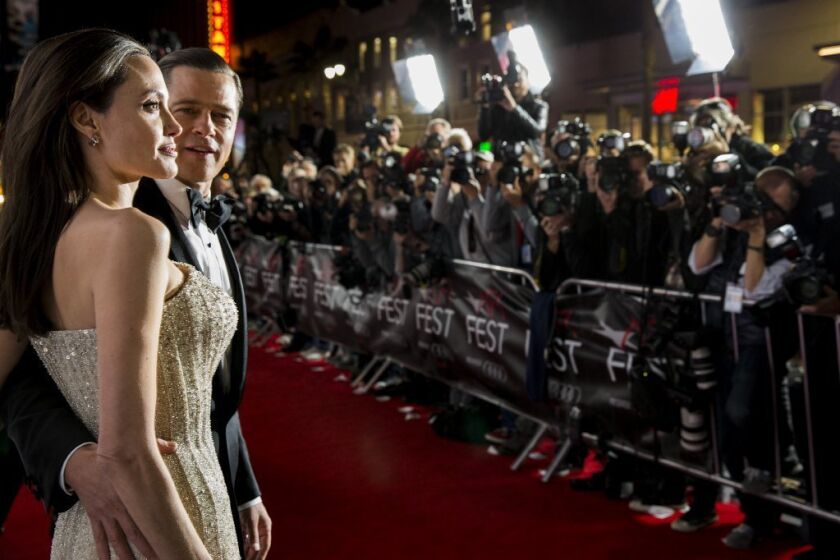 Actress, writer, producer and director Angelina Jolie Pitt and her husband, actor Brad Pitt, pose on the red carpet for the opening night premiere of their new film, "By the Sea," at AFI Fest 2015.