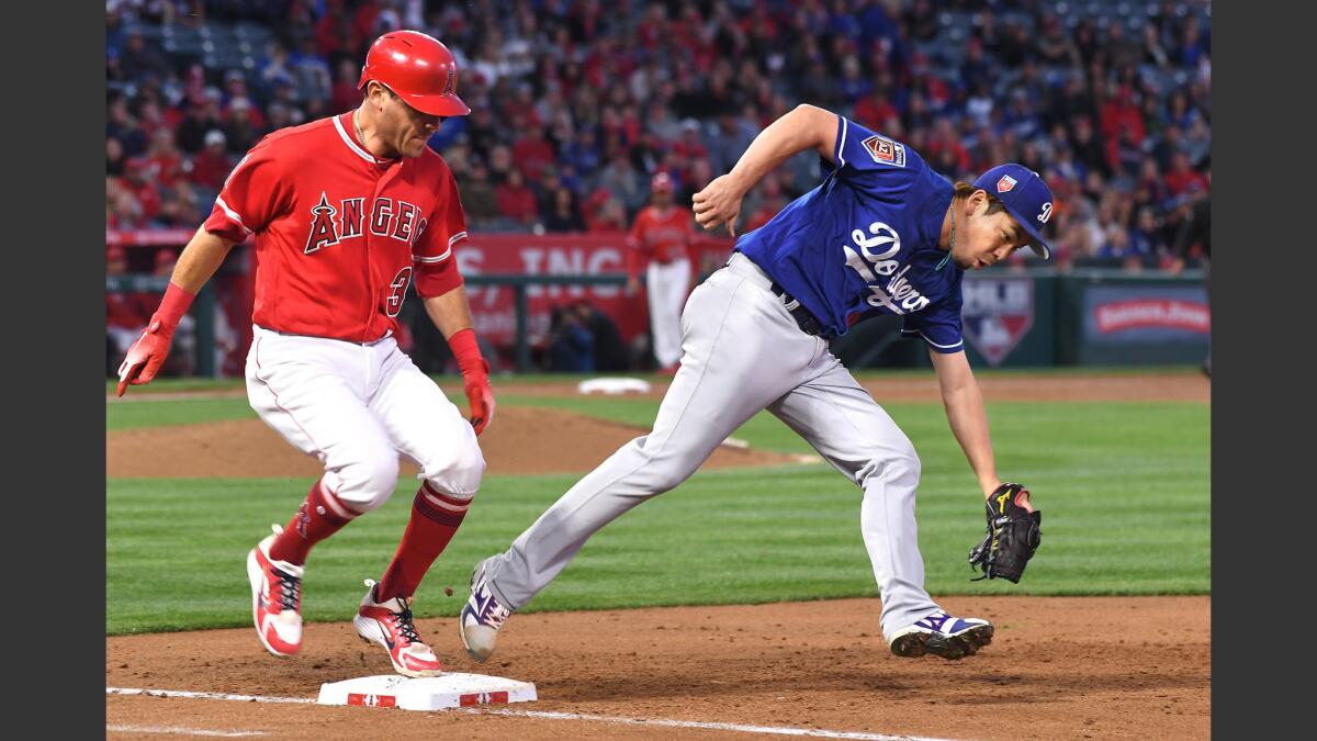 Dodgers pitcher Kenta Maeda beats Angels Ian Kinsler to first base for an out in the third inning. on March 25.