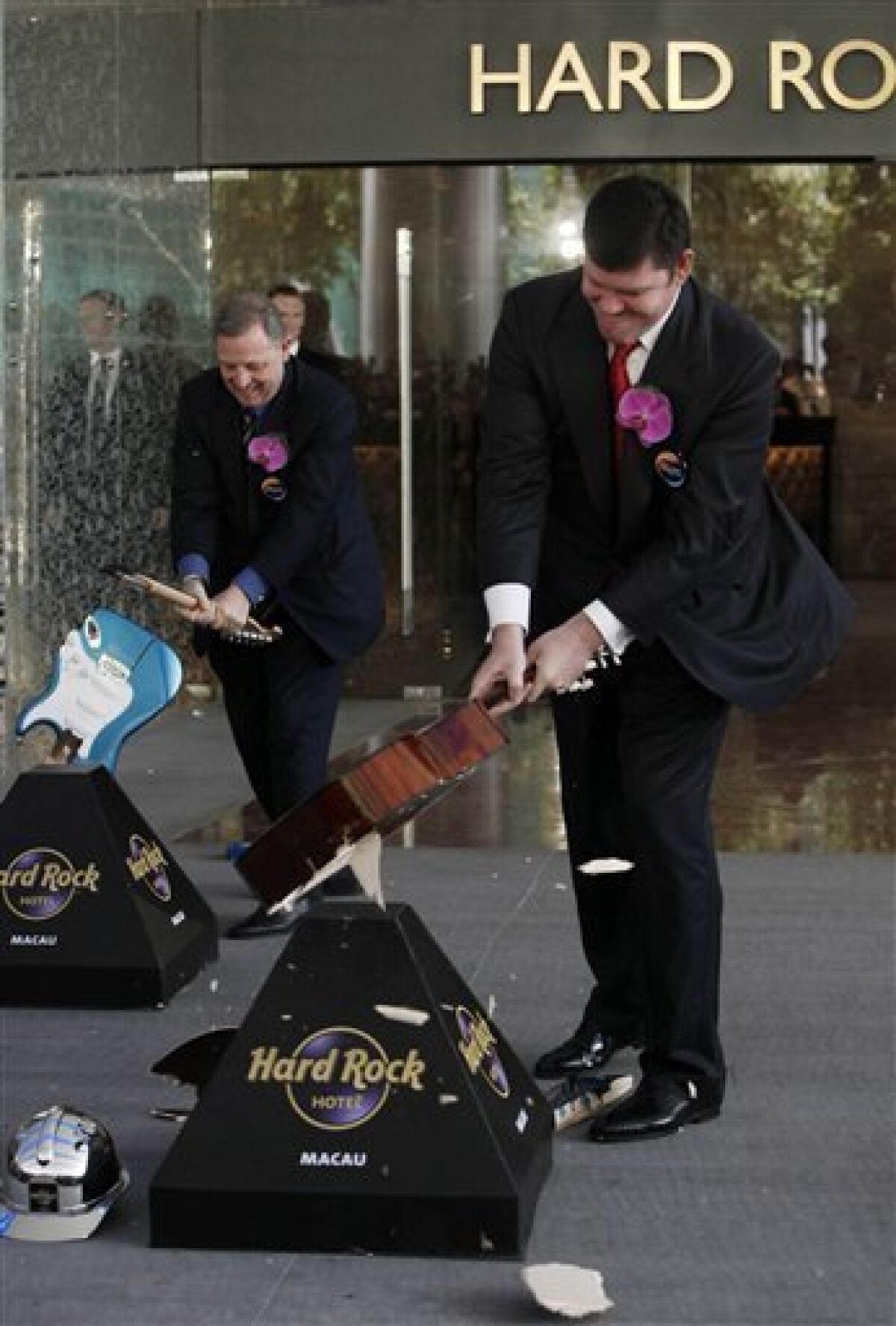 James Packer, right, co-chairman and a director of Melco Crown Entertainment, smashes a guitar during the opening ceremony of the Hard Rock Hotel at the City of Dreams, one of the giant casino complex in Macau, Monday, June 1, 2009. City of Dreams is an urban entertainment resort, feature a 420,000 square foot casino with an underwater theme. It's offer more than 500 gaming tables and 1,350 gaming machines. (AP Photo/Kin Cheung)