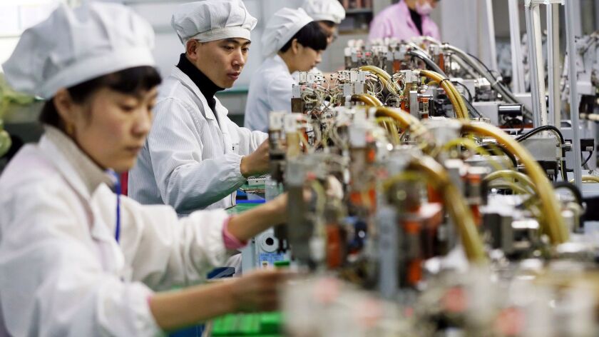 Workers assemble micromotors at a factory in Huaibei in central China's Anhui province on Dec. 8, 2017.