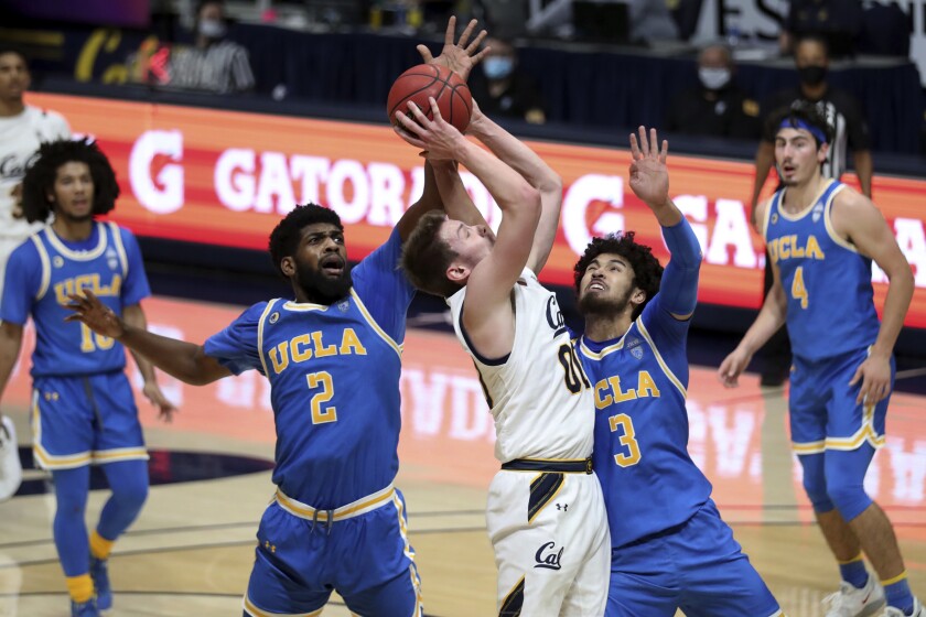 UCLA's Cody Riley, left, and Johnny Juzang defend against California forward Ryan Betley on Jan. 21 in Berkeley.