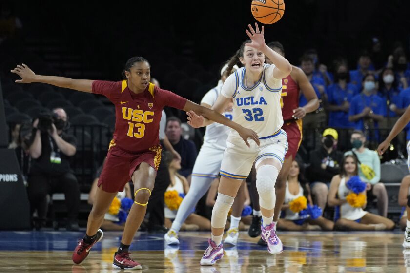 Southern California's Rayah Marshall (13) and UCLA's Angela Dugalic (32) vie for the ball during the first half of an NCAA college basketball game in the first round of the Pac-12 women's tournament Wednesday, March 2, 2022, in Las Vegas. (AP Photo/John Locher)