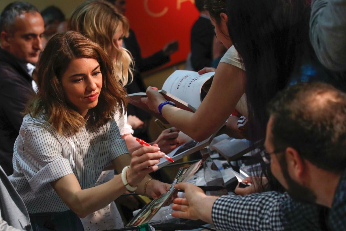 Director Sofia Coppola signs autographs on Wednesday after a press conference for her film "The Beguiled" at the 70th edition of the Cannes Film Festival.