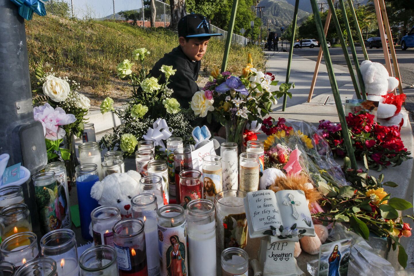 A young boy pays his respects at a makeshift memorial for the shooting victims at North Park Elementary School in San Bernardino.
