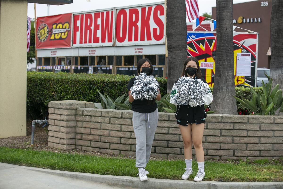 CMHS cheerleaders Nora Moreno, left, and Wendy Martinez on Wednesday promote the team's fireworks stand on 17th Street.