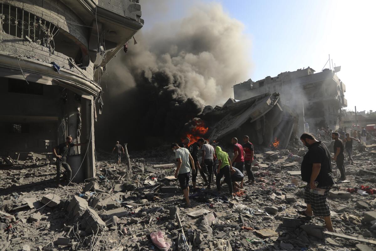 Palestinos inspeccionan los daños de una casa destruida por un ataque aéreo israelí en Ciudad de Gaza, 